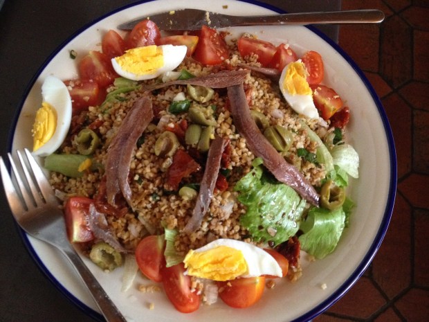 With a boiled egg, lettuce, anchovies, green olives, sundried tomatoes and cherry tomatoes. I also drizzled an extra bit of balsamic vinegar over the top